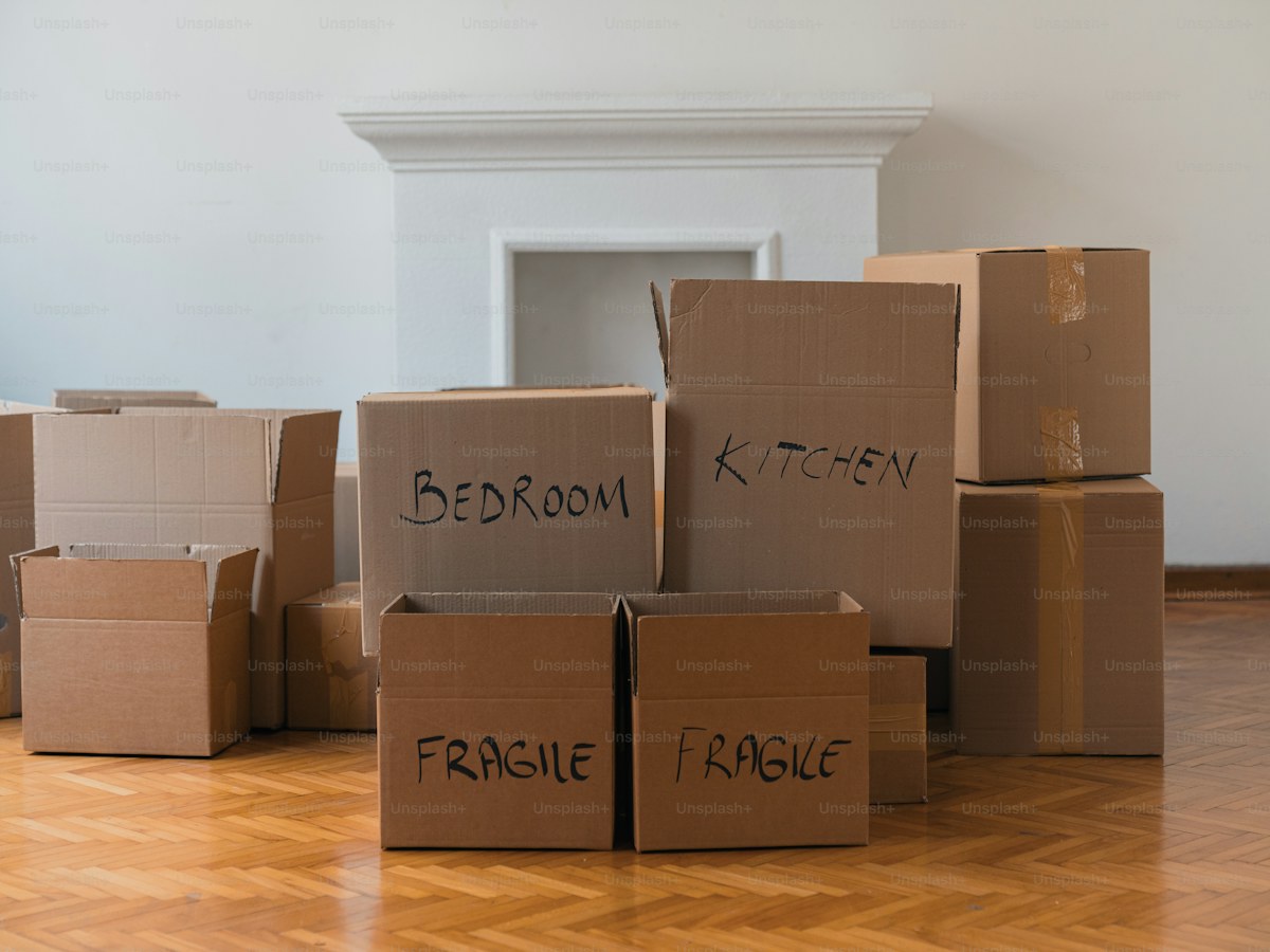 a pile of cardboard boxes sitting on top of a hard wood floor